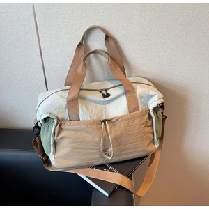 Close-up of lightweight travel bag with tricolor nylon panels and adjustable handles