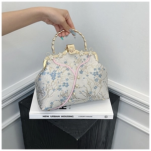 Detail of silk floral embroidery on vintage handbag with bamboo-shaped metal handle