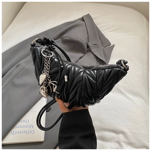 Détail du sac croissant matelassé noir avec chaîne argentée et breloque coeur