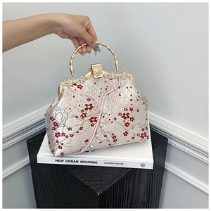 Detail of vintage qipao bag with plum blossom embroidery and bamboo style metal handle