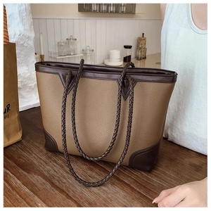 Detail of woven handle and contrast leather corners on the large grainy tote bag