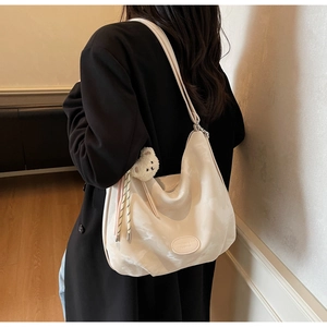 Dettaglio della grande borsa tote a pieghe bianco off-white con un tenero orsetto bianco