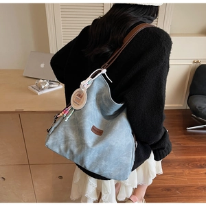 Detail of light blue hobo bag with Banatu logo patch and Loopy cartoon charm decoration