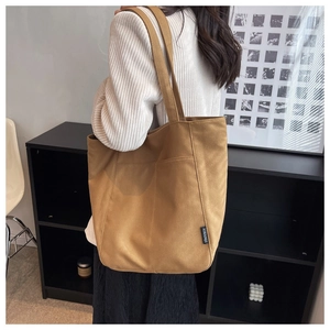 Close-up of a large canvas tote bag with side pocket detail for college students