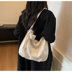 Dettaglio della borsa hobo con ciondolo orsetto e decorazione con sciarpa