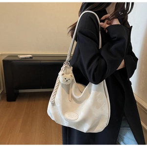 Borsa tote bianca plissettata in tela con ciondolo a orsetto e nastro decorativo