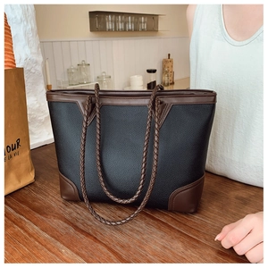 Close-up of color-block tote bag with lychee grain leather and braided handles