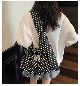 Detail of a large polka dot tote bag with a matching bow and white fabric label