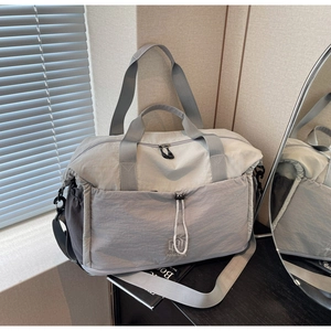 Detail view of the waterproof nylon travel bag with dual handles and adjustable strap