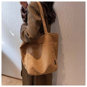 Side view of large camel canvas tote bag on shoulder for casual commute style