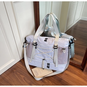 Détail du sac de voyage avec poche avant à cordon et bandoulière réglable