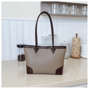 Detail of color-block tote bag with lychee texture leather and woven handles