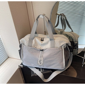 Detail of expandable nylon travel bag with dual-tone color design and shoulder strap