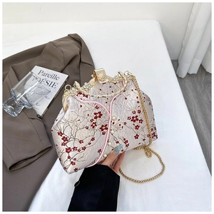 Close-up of vintage cheongsam handbag with red plum embroidery and pearl crystal frame
