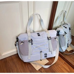 Détail du sac de voyage bleu avec compartiment à chaussures séparé et cordons élastiques