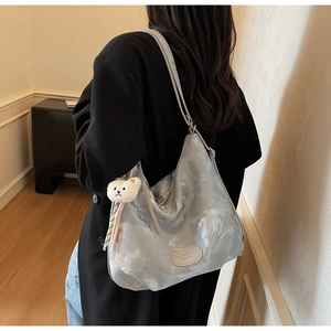 Dettaglio della borsa tote argento testurizzata marmo con ciondolo a forma di orso
