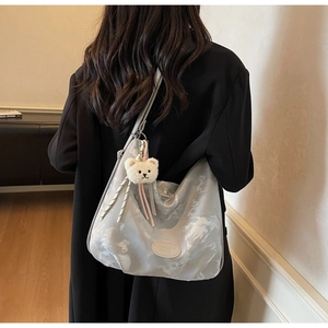 Dettaglio della borsa hobo grigio argento effetto marmo con ciondolo a forma di orso