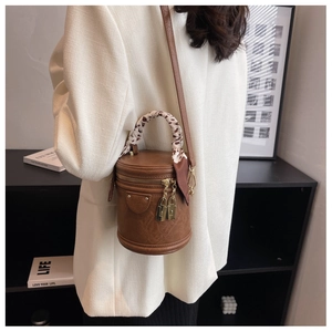 Détail du sac seau marron vintage avec poignée en foulard léopard et serrures dorées