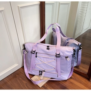 Détail du grand sac de voyage violet avec bandoulière réglable et compartiment spacieux