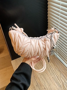 Sac croissant rose matelassé avec surpiqûres verticales et breloques en métal