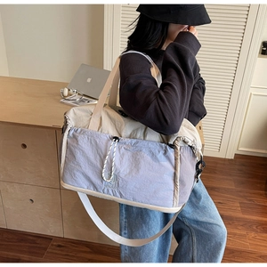 Large travel bag with expandable design shown in a cozy indoor setting with lifestyle items