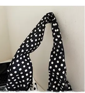 Detailed close-up of the thick canvas handles on a large polka dot pattern tote bag