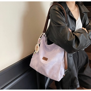 Detail of lavender corduroy tote bag with brown leather strap and colorful bead charm