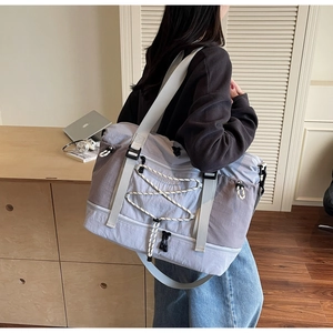 Détail du sac de voyage avec compartiment à chaussures tenu dans un cadre domestique