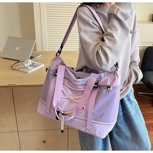 Détail du grand sac de voyage violet avec compartiment à chaussures porté par un mannequin