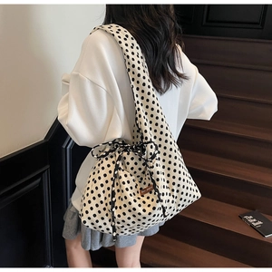 Detail of large polka dot canvas tote bag featuring side drawstring and bow decoration