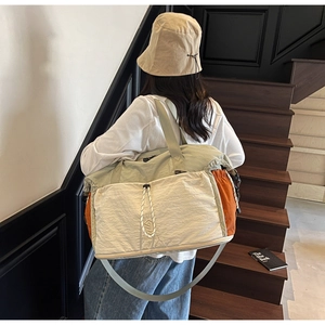 Detail showing tricolor large travel tote with adjustable shoulder strap and NINGJIA logo