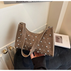 Détail du sac d'épaule en denim marron orné de rivets argentés et bandoulière large