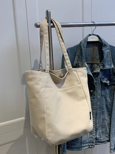 Off-white large canvas tote bag with front pocket and long handles for shoulder carry