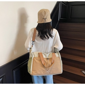 Detail of multi-color travel tote bag showing adjustable shoulder strap and drawstring pocket
