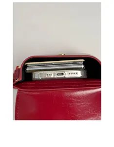 Vertical view showing internal capacity of the red leather mini bag for phone and cards