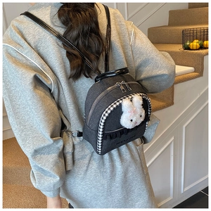 Detail of grey denim mini backpack featuring cute bunny plush and checkered trim
