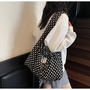 Detail view of large capacity polka dot tote bag with stylish bow and brand label