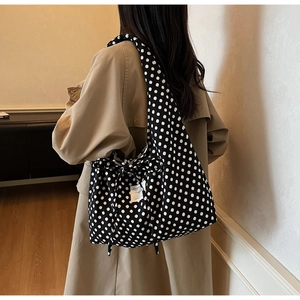 Detail showing side view of large polka dot tote bag with drawstring on model