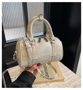 Détails du sac Boston blanc crème avec cuir texturé et fermetures éclair métalliques robustes
