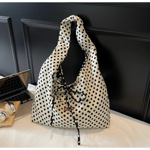 Detail of large canvas tote bag with polka dot pattern and a stylish ribbon bow knot