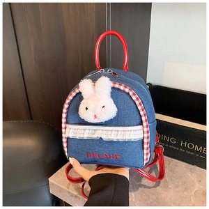 Detail of denim backpack showing 3D plush rabbit head and fine lace decorations