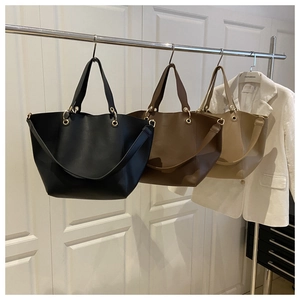Detailed view of large capacity tote bags with gold hardware and removable straps