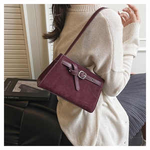 Détail du sac à bandoulière bordeaux givré avec boucle porté avec une tenue décontractée