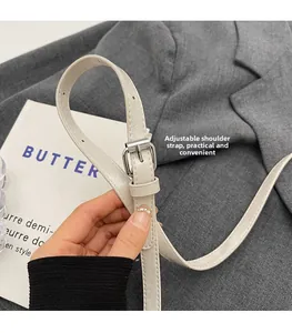 Détail de la bandoulière réglable en similicuir crème avec boucle en métal argenté