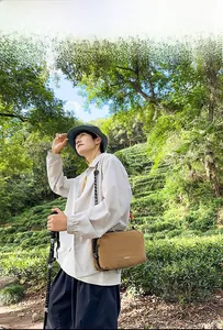 Hiking bag detail showing khaki nylon fabric and logo in a natural outdoor setting