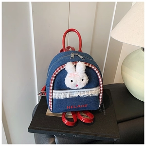 Detail of denim mini backpack with plush bunny accent and red checkered trim contrast