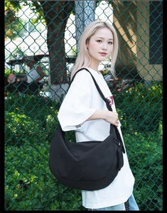 Detailed view of black nylon crescent bag with adjustable strap and detachable pouch
