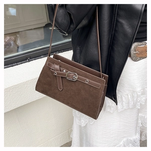 Détail d'un petit sac bandoulière marron foncé mat porté par un mannequin