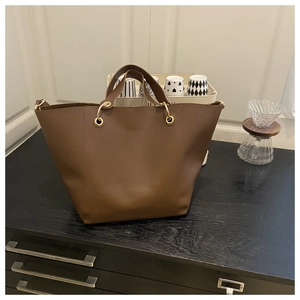 Close-up of a vintage brown tote bag with premium leather texture and gold hardware ring
