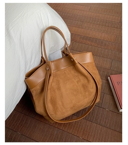 Detail of caramel faux leather tote bag with suede texture and metallic rivet accents